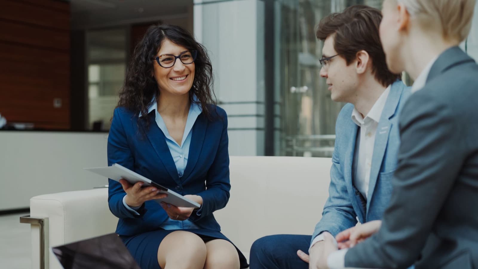 Consultants discussing business strategy around a table in a modern office lounge.